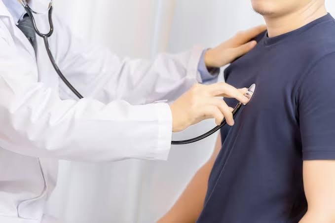 Cardiologista ausculta o tórax de um paciente com estetoscópio durante a consulta